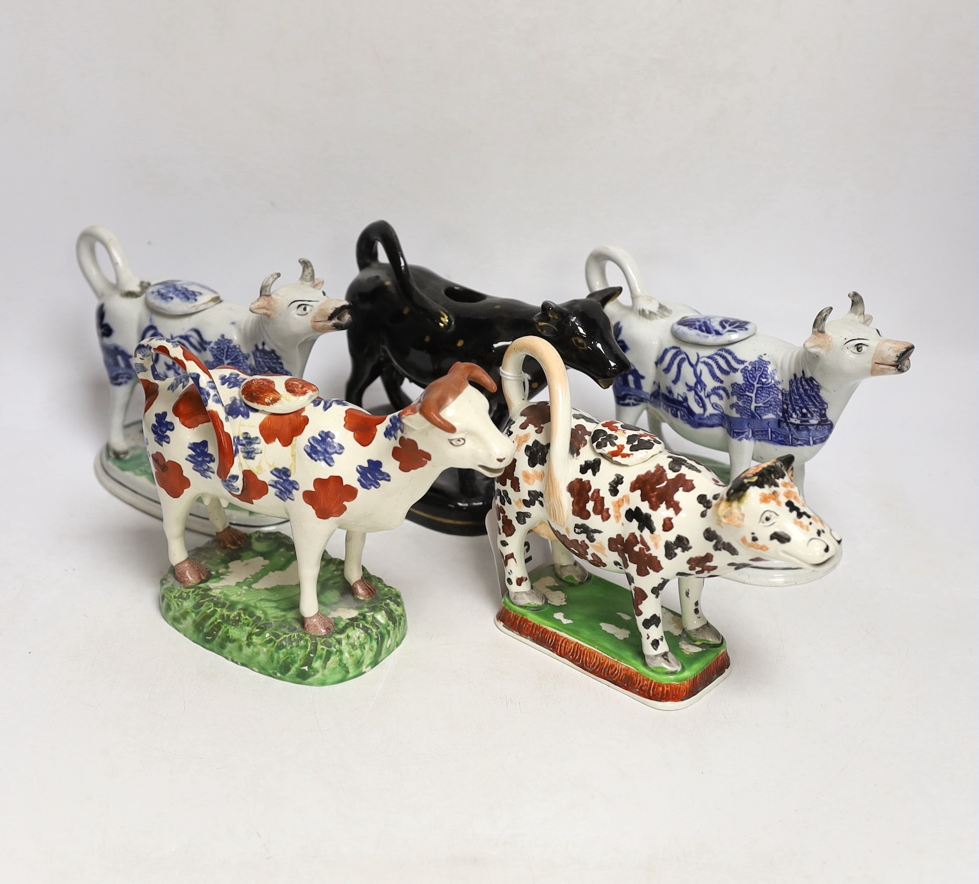 Five 19th century Staffordshire cow creamers, largest 18cm wide